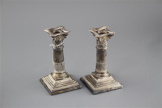 A pair of Edwardian silver corinthian column dwarf candlesticks by Williams Ltd, Birmingham, 1905, height 16.4cm, weighted, a.f.